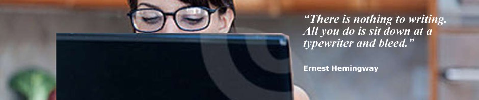 photograph of a woman wearing reading glasses, looking at a computer screen