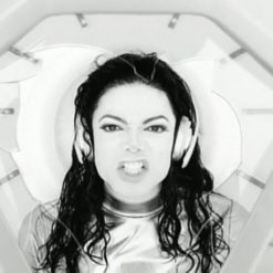 Close-up of Michael Jackson’s anguished expression as he sings “Stop pressurin’ me,” surrounded by sterile white walls.