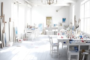 Working From Home - White atelier. A painter or artist atelier, craft room, with white interior. Lots of paint, paint brushes, and paint sumdges and splatters