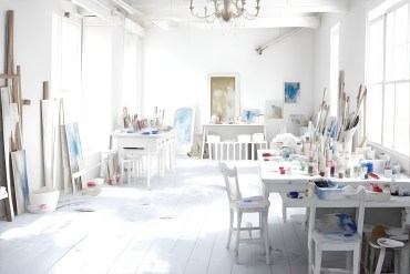 Working From Home - White atelier. A painter or artist atelier, craft room, with white interior. Lots of paint, paint brushes, and paint sumdges and splatters