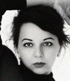 Black-and-white self-portrait of artist Lee Wilde, gazing directly at the viewer with quiet intensity.