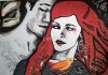 Painting titled Bad Little Bird depicting two intimate figures — a man with shaded face and closed eyes leaning toward a red‑haired woman with pale skin, red lips, and a large earring, with a small orange bird perched on her chest.