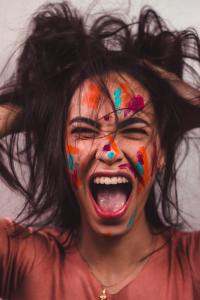 Very excited female artist with paint on her face