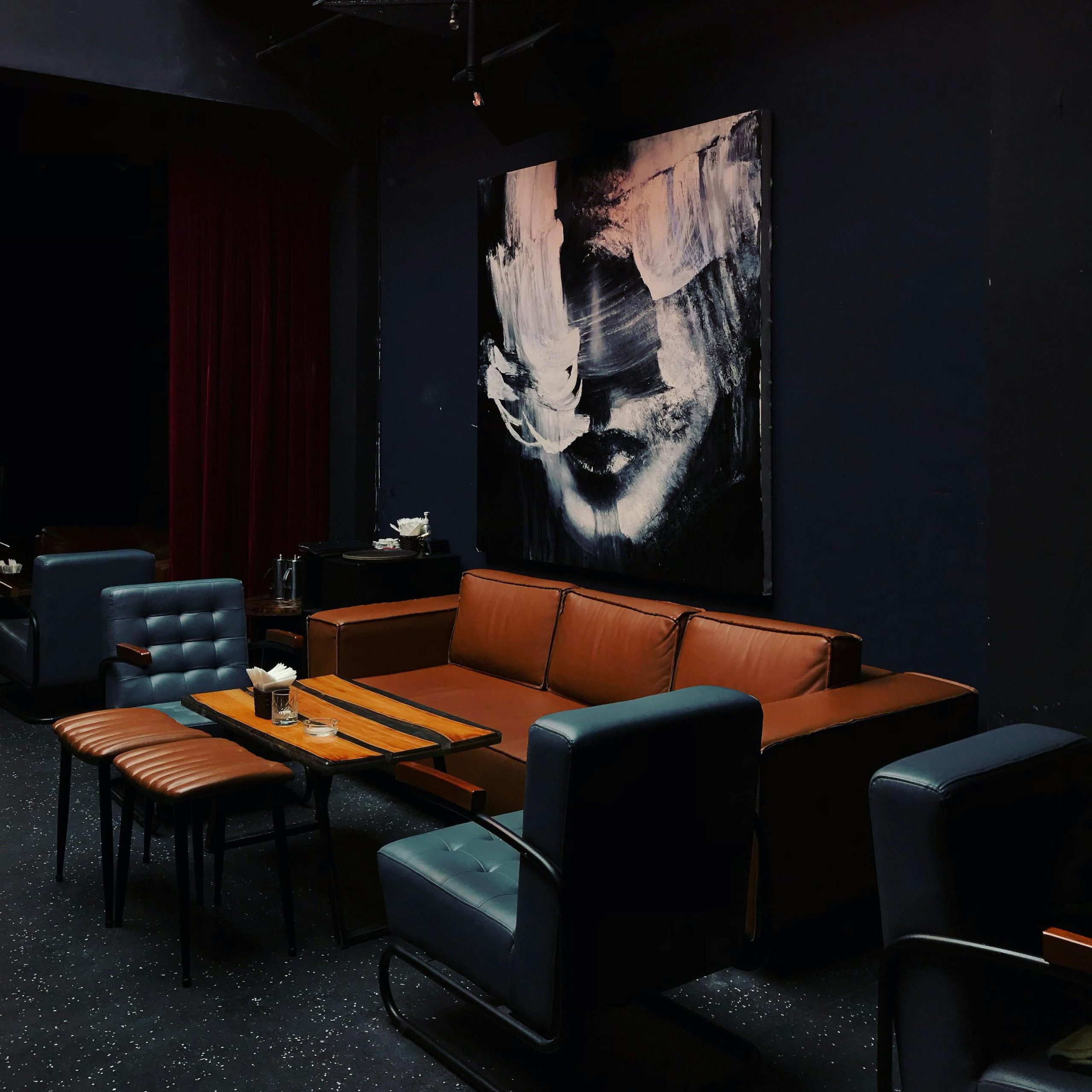 A striking black and white portrait hanging in a darkened dining room