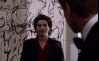 Julia Ormond in a scene from Sabrina (1995), standing before Willem de Kooning’s 1949 Abstract Expressionist painting Attic, visible in the background of a corporate interior.