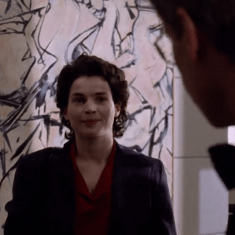 Julia Ormond in a scene from Sabrina (1995), standing before Willem de Kooning’s 1949 Abstract Expressionist painting Attic, visible in the background of a corporate interior.