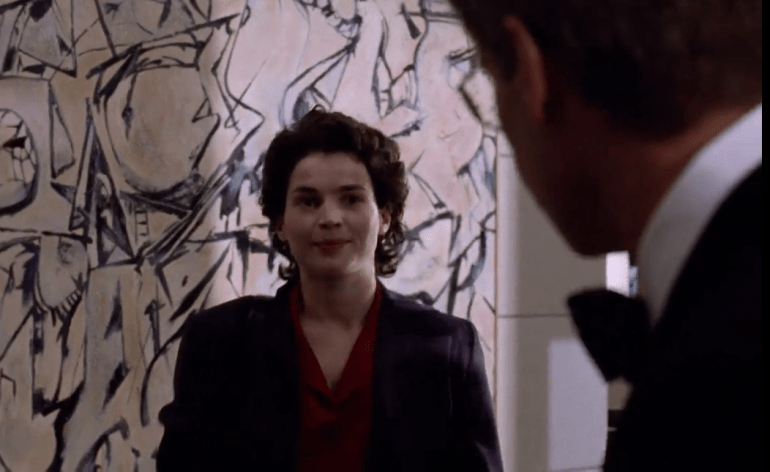 Julia Ormond in a scene from Sabrina (1995), standing before Willem de Kooning’s 1949 Abstract Expressionist painting Attic, visible in the background of a corporate interior.