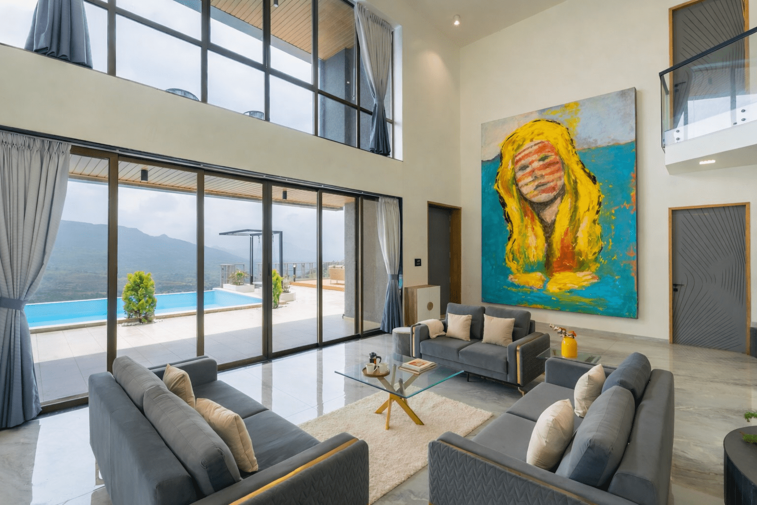 Unframed canvas of Lee Wilde’s painting Heat Waves mounted on a light wall in a modern living room overlooking a pool and mountain landscape. The expressive yellow and turquoise composition introduces a surreal, symbolic presence within the minimalist space.