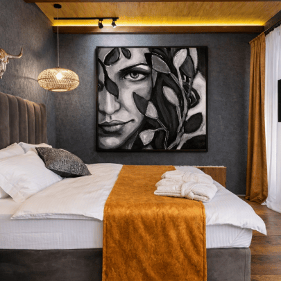 Figurative painting ‘Mina’ in monochrome noir style displayed in a contemporary rustic bedroom interior — figurative art for interiors.