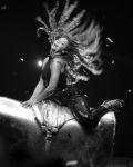 Black‑and‑white photograph of Beyoncé in motion, captured mid‑performance on a large metallic cylinder. Her sequined outfit catches the light as her hair fans outward dramatically, creating a sense of rhythm and power. The industrial backdrop and reflective surfaces evoke the *Suga Mama* video’s monochrome aesthetic — a fusion of sensual movement, texture, and strength that defines the Sonic Noir style.